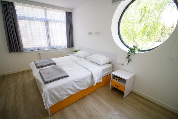 Bračna soba s velikim prozorom i prirodnim svjetlom u domu za starije Senior Garden