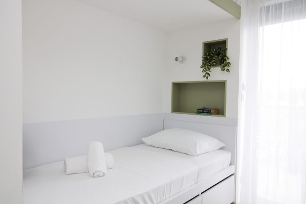 Krevet u dvokrevetnoj sobi s pogledom na balkon