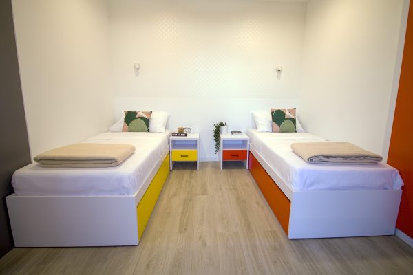 Kreveti s noćnim ormarićima u spavaćem dijelu dvosobnog apartmana za starije osobe