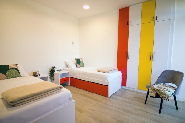 Spavaći dio s krevetima, ormarom i noćnim ormarićima u dvosobnom apartmanu doma za starije osobe