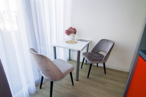 Stol s dva stolca uz prozor u dvosobnom apartmanu doma za starije osobe